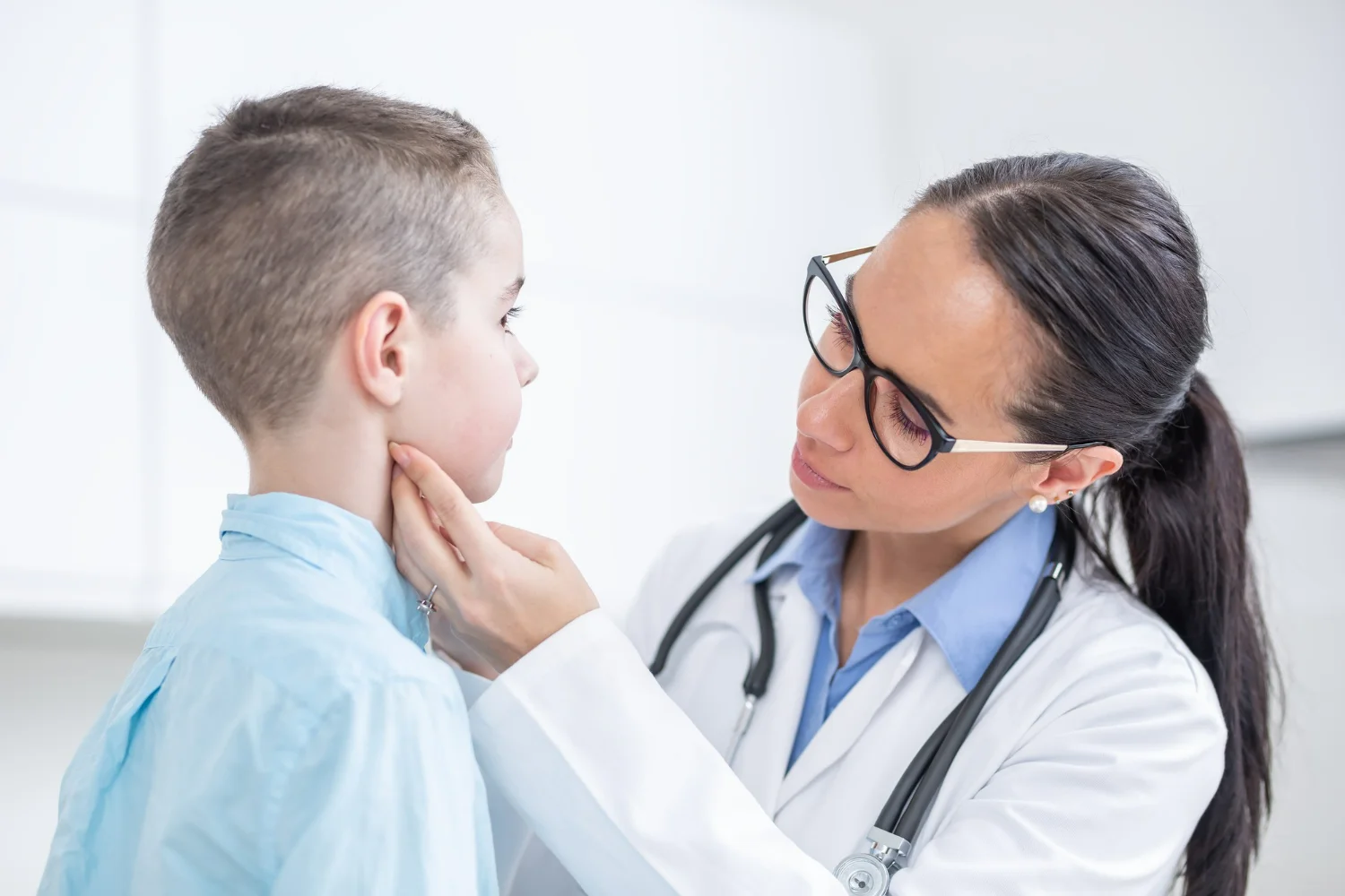 Médica endocrinologista examina menino para diagnosticar hipotireiodismo em crianças