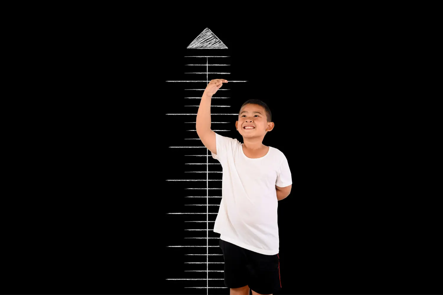 Um menino sorridente mede a sua altura.