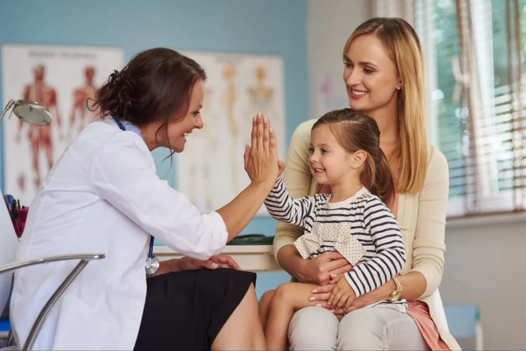 uma médica realiza consulta com mãe e filha.